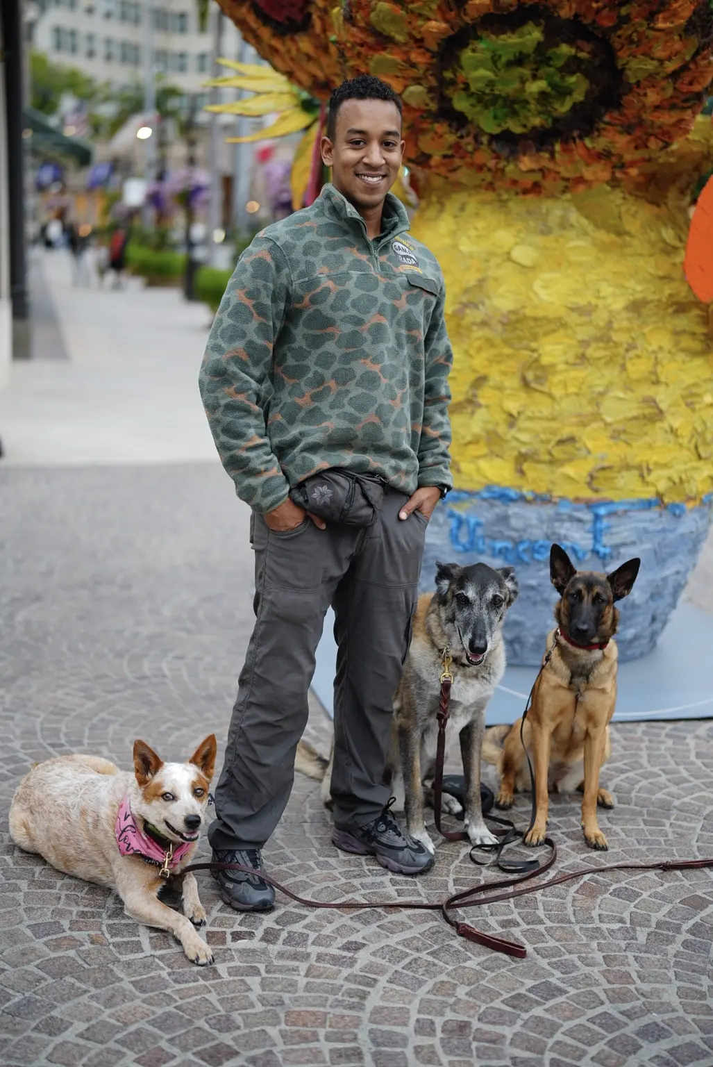 Phillip standing with three dogs in his Gamarada camo shirt